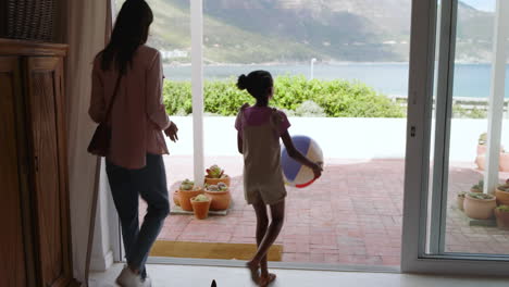 mother and daughter enjoying sunny day on patio with beach ball