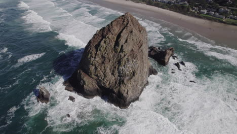 Huge-rock-protrudes-from-the-water-at-Cannon-Beach,-Oregon