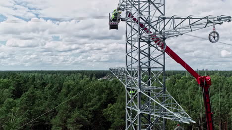 Workers-on-high-voltage-pylon-and-surrounding-landscape