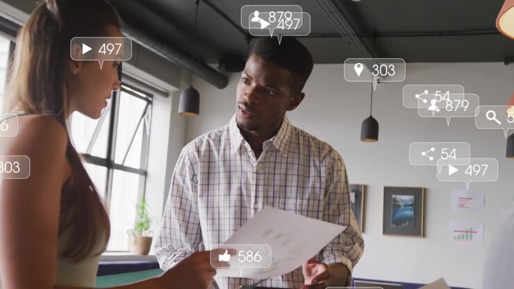 Intern pointing at green folder and man studying paper, sparking social icons showing media reach