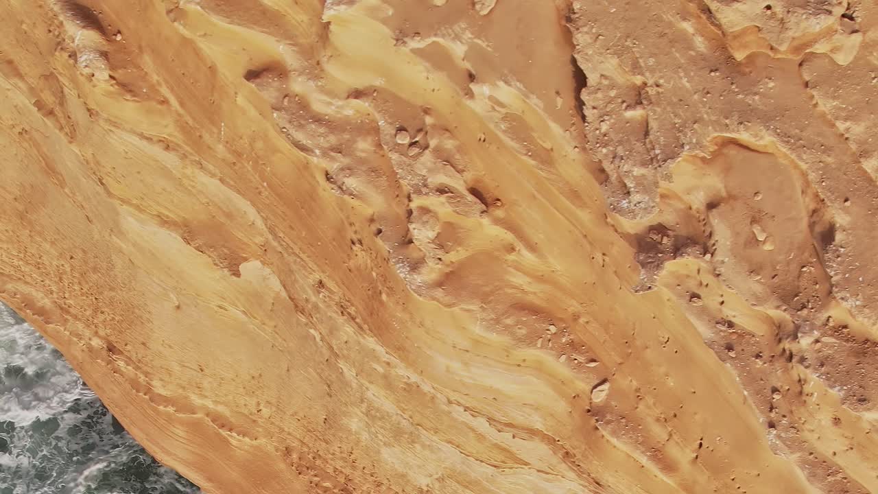 Flygvy över marockansk kustlinje med sandiga klippor och hav.