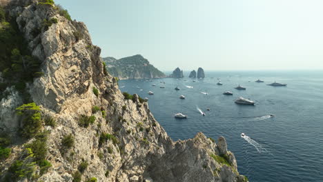 drone dolley shot of grotta verde cliff where large yachts are anchored at the island capri