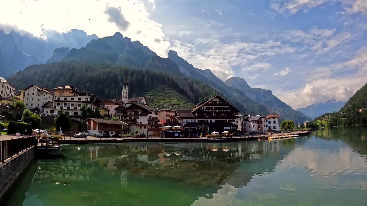 Turisti che passeggiano nel pittoresco villaggio di Alleghe, Dolomiti, Italia, in estate