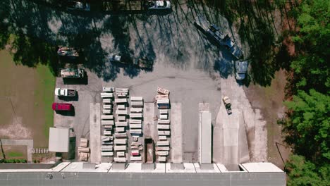 forklift truck operator exiting a warehouse with of vinyl siding building material construction to load a hotshot pickup truck