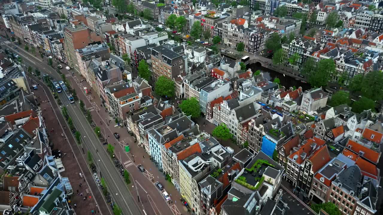 Drone flies forward over streets and canal in Amsterdam (60fps)