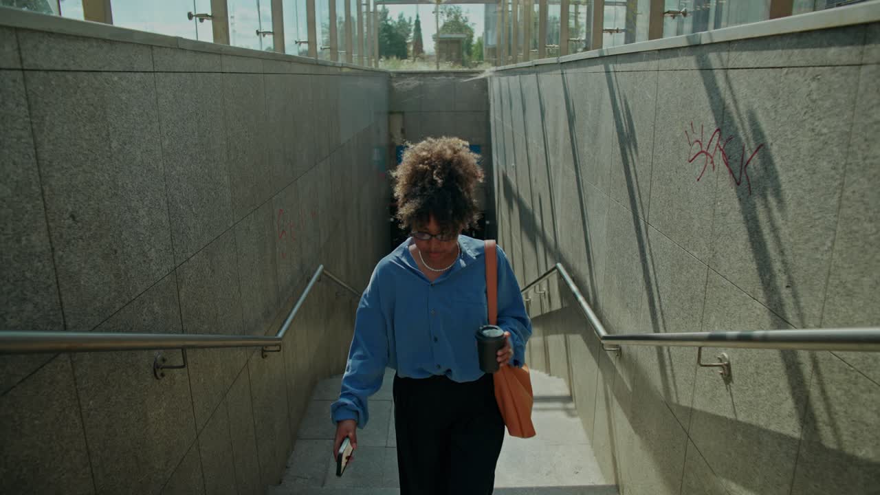 A woman walks down stairs into an underground tunnel