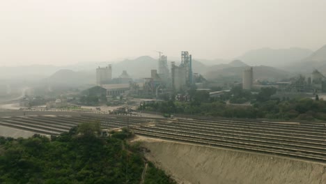 aerial footage of cement factory with a solar field in foreground in pakistan.