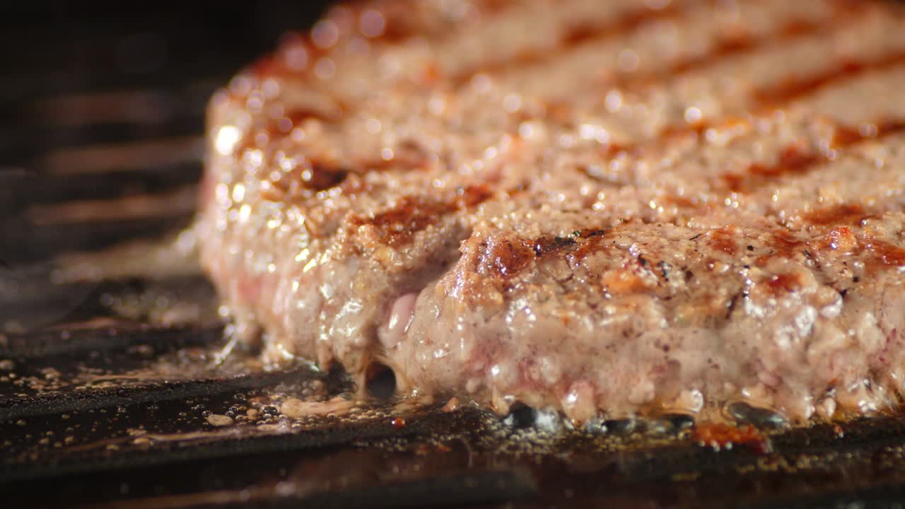 la carne frita de la hamburguesa en la sartén gira lentamente.