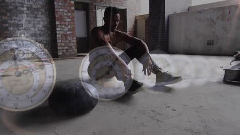 multiple hanging clocks against african american man taking a break from working out