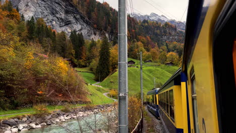 switzerland swiss alps train ride grindelwalk jungfrau interlaken to lauterbrunnen late october november autumn fall colors river late afternoon bernese overland thun bern region snow peak glacier