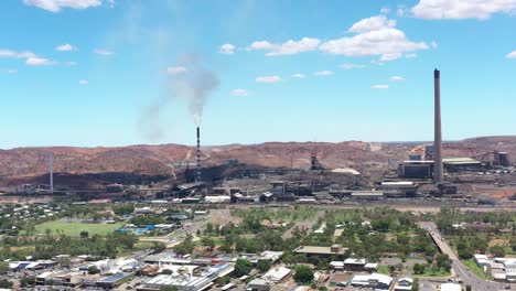 Ausgezeichnete-Luftaufnahme-Des-Verkehrs-In-Der-Nähe-Der-Schornsteine-Eines-Industriezentrums-In-Mount-Isa,-Australien