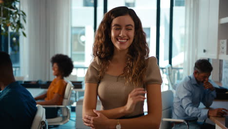 Portrait-Of-Young-Smiling-Businesswoman-Standing-In-Modern-Office