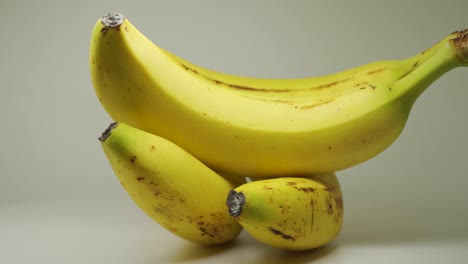 Four-Freshly-Picked-Ripe-Bananas-On-A-Turntable---Close-Up-Shot