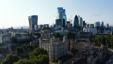 Aerial-view-of-medieval-stone-keep-with-four-towers-in-corners.-Castle-Tower-of-London-contracting-with-modern-downtown-skyscrapers-in-City.-London,-UK