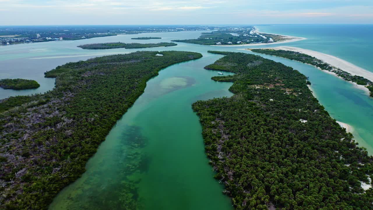 Mangrove-covered islands stretch between shallow turquoise channels that wind toward Stump Pass, revealing sandbars and the sweeping Gulf shoreline of Manasota Key on Florida’s southwest coast