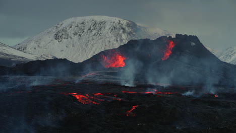 geldingadalur eruption with snowy mountain in background in reykjavik, iceland