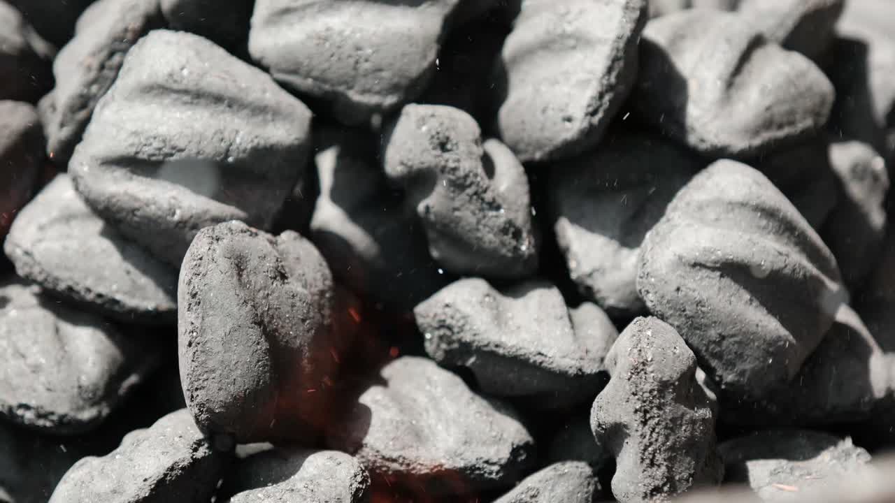 Slow-motion close-up of burning charcoal with glowing embers and drifting sparks. Ideal for BBQ scenes, cooking visuals, summer ads, and dramatic heat-related content. 3 of 3