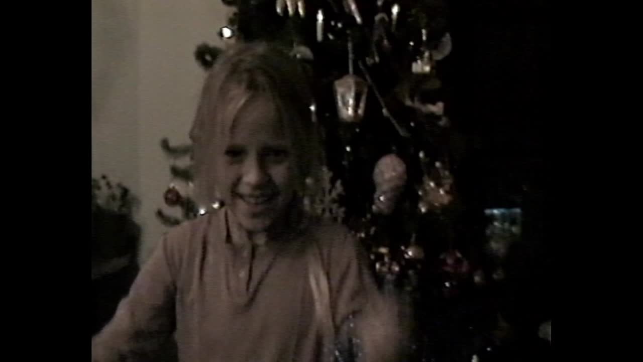 Smilende barn foran pyntet juletre