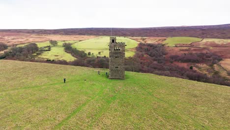 Altes-Verfallenes-Schloss,-Denkmal,-Stillgelegter-Steinturm,-Mit-Leuten,-Die-Herumlaufen-Und-Eine-Drohne-Fliegen