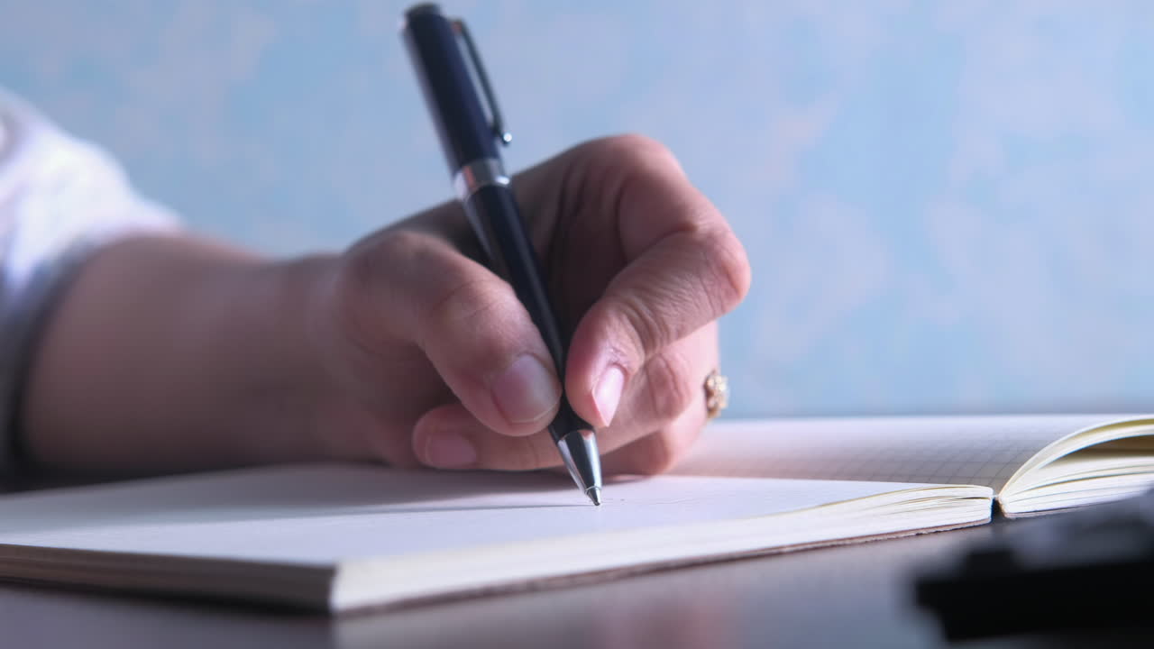 Person Writing in a Notebook