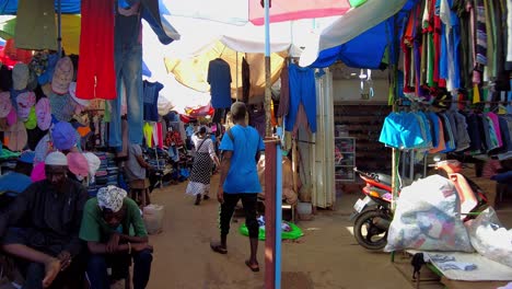 pov walking through serekunda market with colorful traditional hand-made attire on display