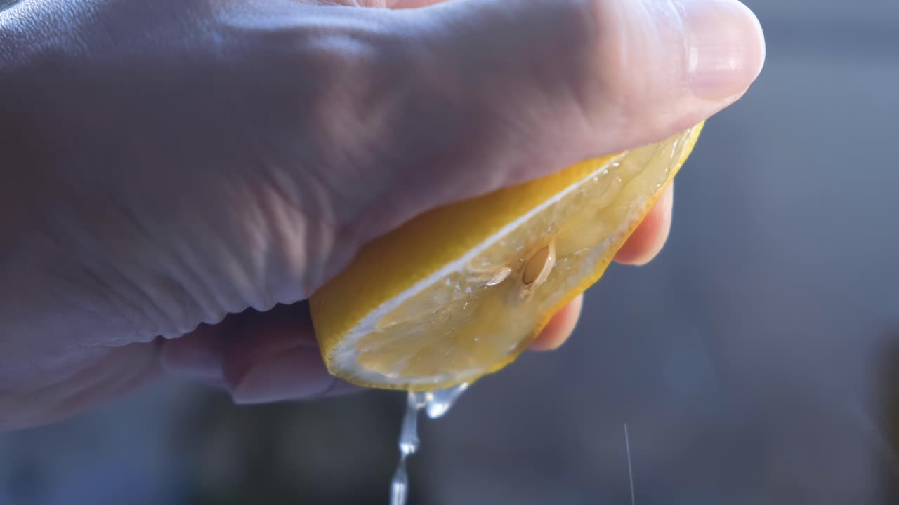 la mano de un chef exprimiendo un limón fresco