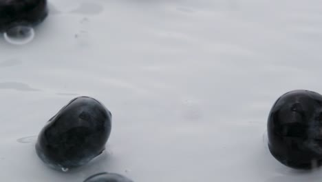 arándanos salpicados en el agua, macro shot en cámara lenta, fruta fresca y saludable