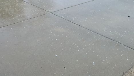 hail during rainstorm on a driveway, close up