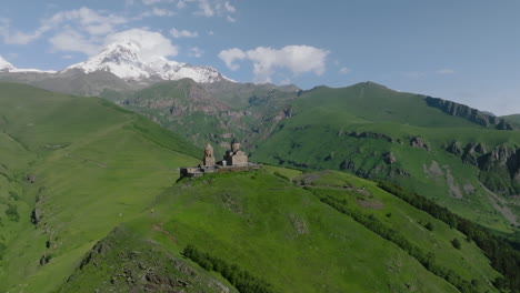 gergeti trinity church on top of the hill in georgia - aerial drone shot