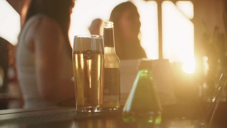 Primo piano di una birra al bancone del bar e mani che la portano via, Basilea, Svizzera