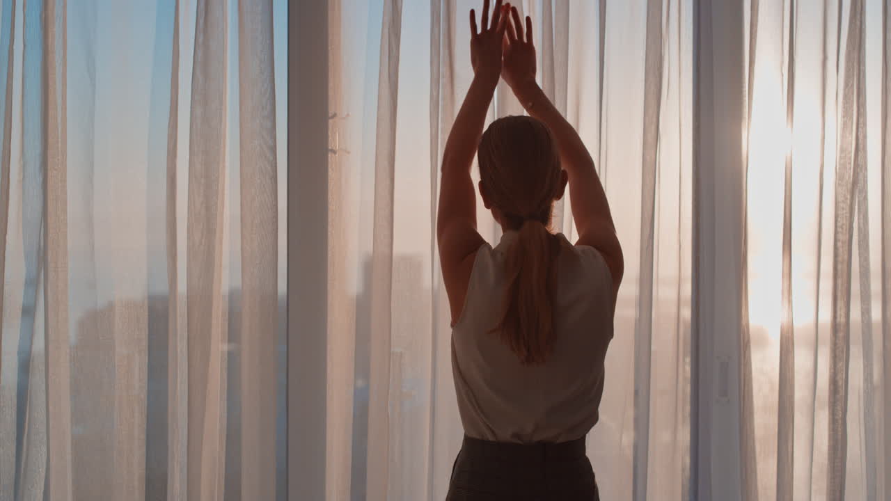 mujer de negocios abriendo cortinas en la habitación del hotel mirando por la ventana al fresco nuevo día exitosa mujer independiente planeando adelante al amanecer