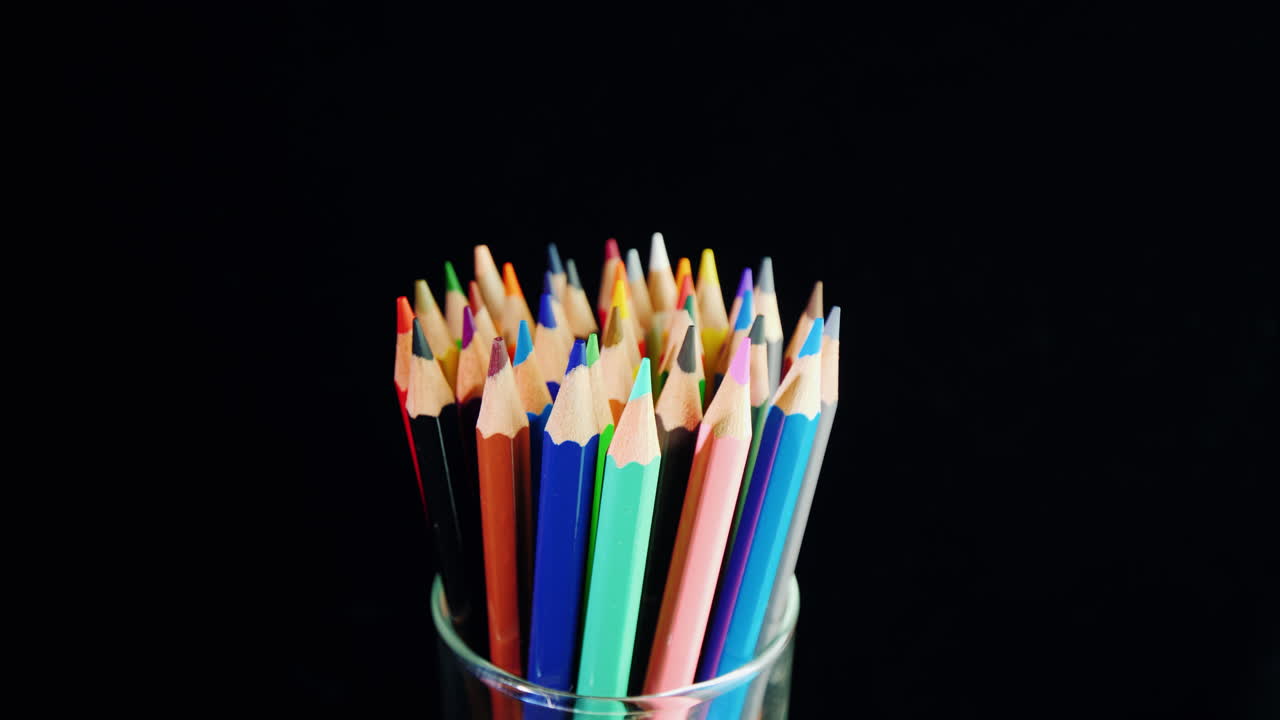 un juego de lápices multicolores sobre un fondo negro