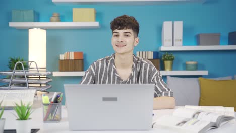 joven sonriendo mirando a la cámara mientras lee. hace un gesto positivo.
