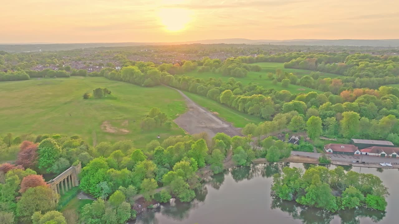 Aerial: Heaton Park at sunset with lake during the day in Prestwich, Manchester, England, static drone shot