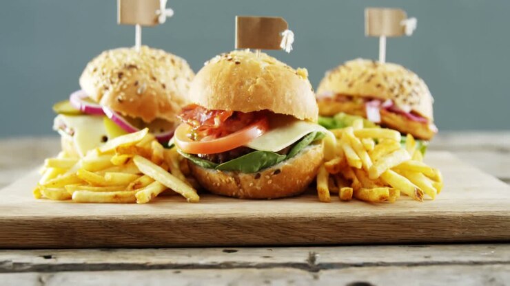 Hamburgers arranged on wooden board