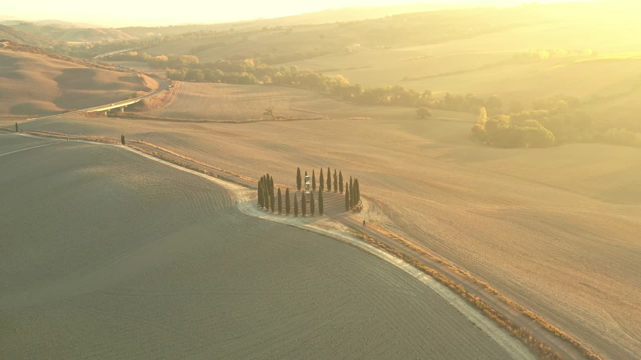 vista aérea de las hermosas colinas del val d'orcia en la toscana con el bosque en forma de círculo de ciprés cerca de montalcino, italia, colinas cultivadas con trigo, columna iónica por helidon xhixha, reflejos
