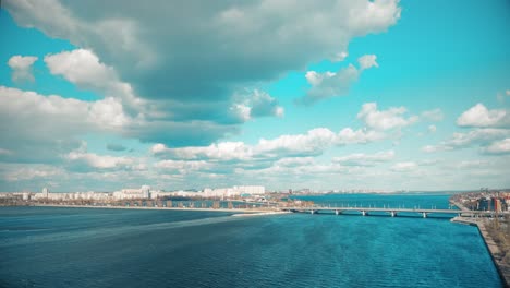 cityscape with river and bridge under a cloudy sky