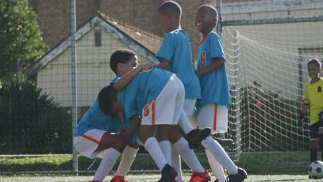 soccer kids in blue smiling and cheering up in a sunny day