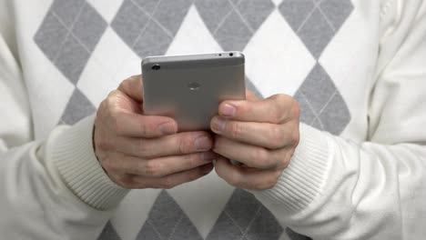 un hombre escribiendo un mensaje en su teléfono inteligente.