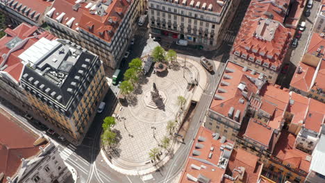 Aerial-view-of-small-oval-square-with-ornamental-pattern-on-tiled-pavement-and-statue-in-center.-B13-Square-from-drone.-Lisbon,-capital-of-Portugal.