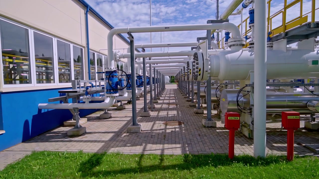 Moderne industrianlæg med rør og ventiler til transport af naturgas og råolie.