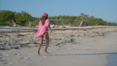Thin-latin-girl-in-a-bikini-and-a-shirt-running-on-the-beach-enjoying-her-self-on-a-sunny-day
