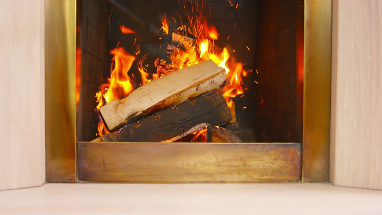 불타는 나무를 철 포커로 고, 불꽃이 날아다니며, 집 안에서 따뜻함과 편안함을 만드는 흥미로운 인테리어 솔루션