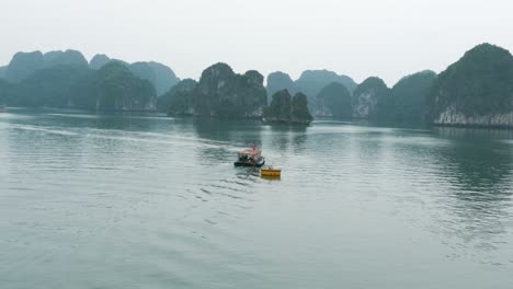 mystical ha long bay: small boat adventure heading to limestone islands on a gloomy day