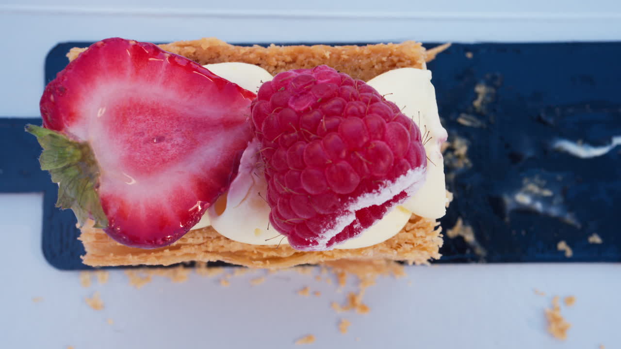 Close up of a pice of cake with cream and berries on top