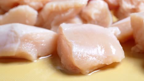 carne de pollo cruda en un plato sobre un fondo blanco