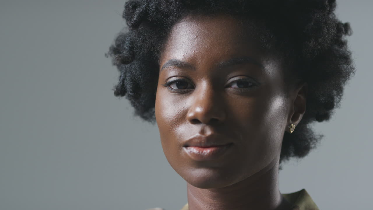 retrato de estudio de una joven soldado en uniforme militar contra un fondo plano