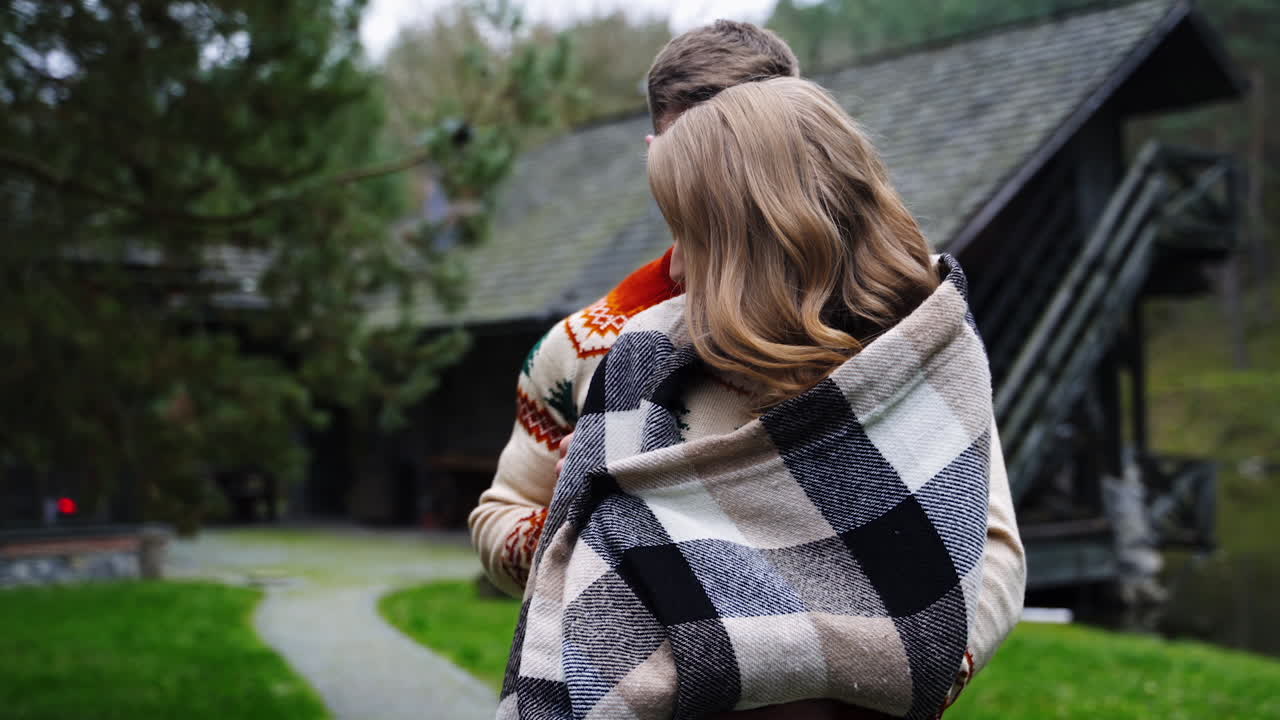 Loving couple in the village. Young man standing close to his girlfriend outdoors. Romantic couple enjoys the time together on nature background.