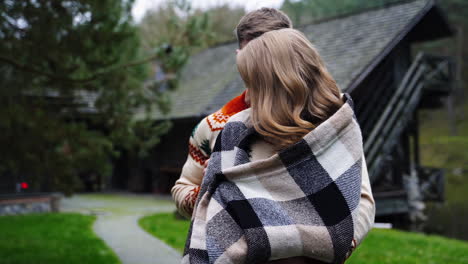 loving couple in the village. young man standing close to his girlfriend outdoors. romantic couple enjoys the time together on nature background.