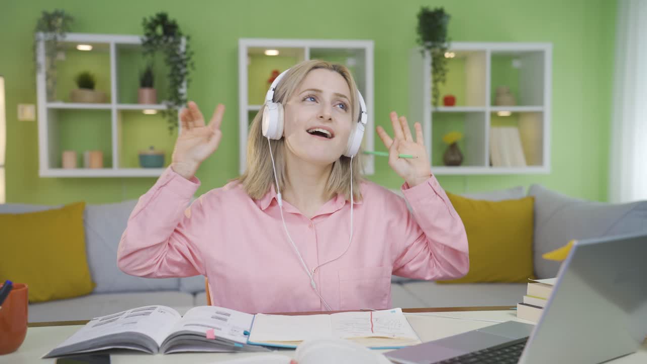 대학생 소녀가 공부하는 동안 춤을 추고 있습니다.